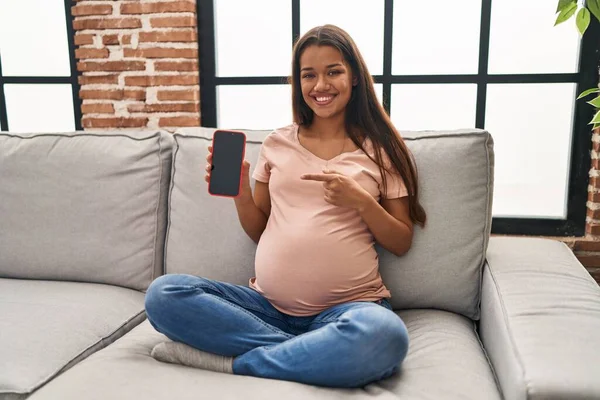 Jonge Zwangere Vrouw Met Smartphone Met Scherm Glimlachend Gelukkig Wijzend — Stockfoto