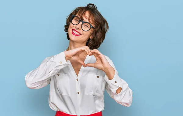 年轻的惊慌失措的女人 戴着商务风格的眼镜 带着爱的笑容 用手做着心形符号 浪漫的概念 — 图库照片