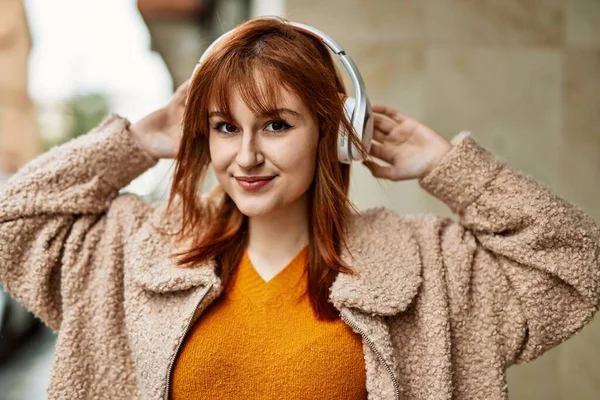 Genç Kızıl Saçlı Kız Şehirde Kulaklık Takarak Mutlu Bir Şekilde — Stok fotoğraf