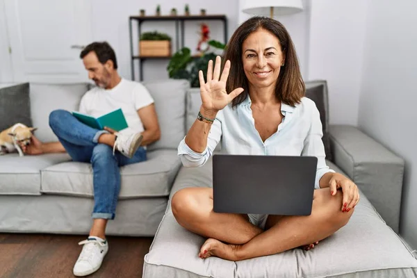 Hispanic Middle Age Couple Home Woman Using Laptop Showing Pointing — Stock Photo, Image