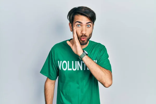 Jovem Hispânico Vestindo Voluntário Shirt Mão Boca Dizendo Rumor Secreto — Fotografia de Stock