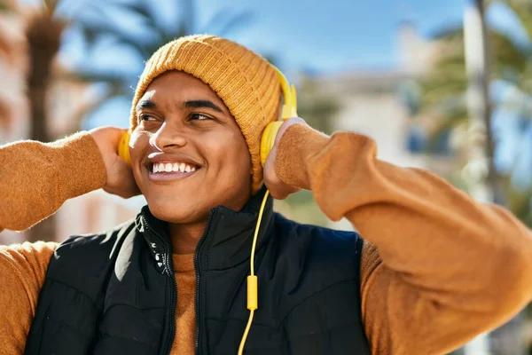 若いラテン語の男笑顔幸せな使用ヘッドフォンで市内 — ストック写真