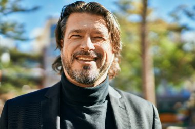 Orta yaşlı işadamı şehirde mutlu mesut dikilirken.