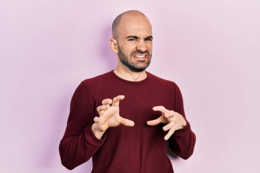 Genç kel bir adam günlük giysiler içinde tiksindirici bir ifade takınıyordu. Tiksinti tepkisi yüzünden tiksindirici ve korkunç bir ifade takınıyordu. Eller havada. 