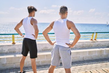 İki İspanyol erkek, deniz kenarında duran deniz manzaralı spor bir çift.