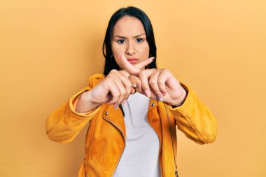 Burnu delinmiş, sarı deri ceketli güzel İspanyol bir kadın. Reddedilmiş yüz ifadesi. 