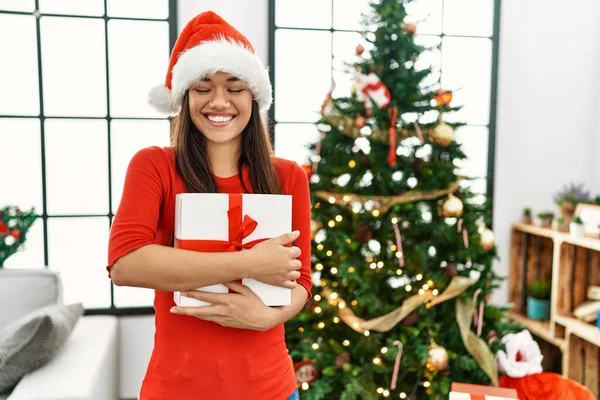 Young Latin Woman Hugging Gift Standing Christmas Tree Home — Stock Photo, Image