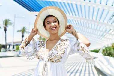 Sokakta kendinden emin gülümseyen genç İspanyol kadın.