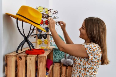 Genç İspanyol kadın gülümsüyor. Giyim mağazasında kendine güveni tam.