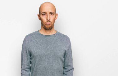 Kel, sakallı, günlük giysiler giyen, sıkıntılı, sinirli ve korkmuş bir adam. hüzünlü ifade. 