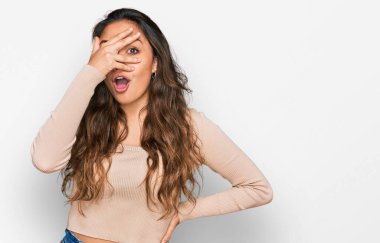 Gündelik kıyafetler giyen genç İspanyol kız şok içinde yüzünü ve gözlerini kapayarak utanmış ifadesiyle parmaklarından bakıyor.. 