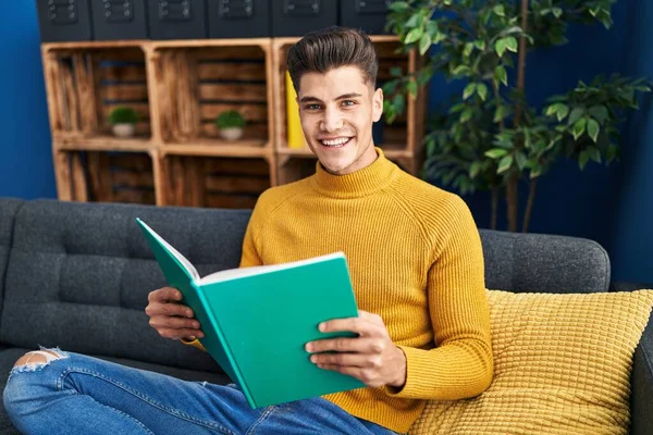 Joven Hombre Hispano Leyendo Libro Sentado Sofá Casa — Foto de Stock