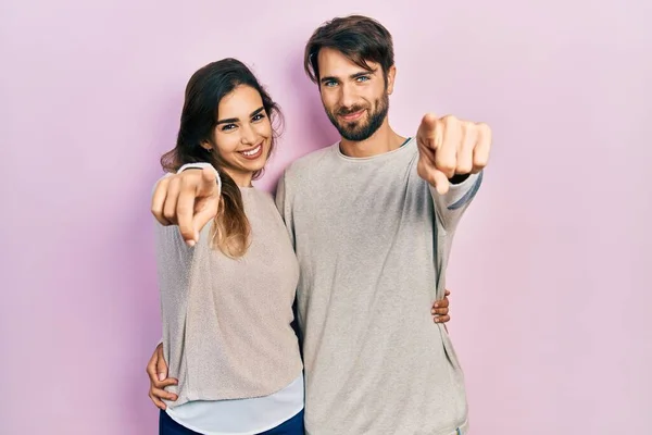 若いヒスパニック系のカップルはあなたを指してカジュアルな服を着て 指でカメラ 笑顔正と陽気な — ストック写真