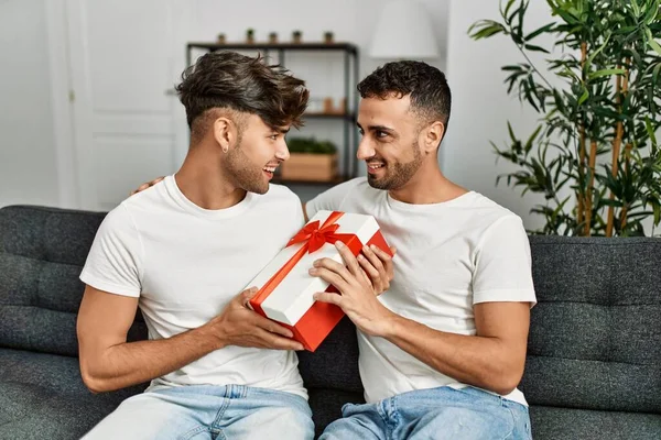 Dos Hombres Hispanos Pareja Sonriendo Confiada Sorpresa Con Regalo Casa —  Fotos de Stock