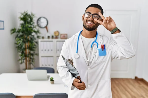 Young Indian Man Wearing Doctor Uniform Stethoscope Doing Peace Symbol — Stock Photo, Image
