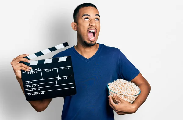 Giovane Uomo Afroamericano Mangiare Popcorn Tenendo Pellicola Clapboard Arrabbiato Pazzo — Foto Stock