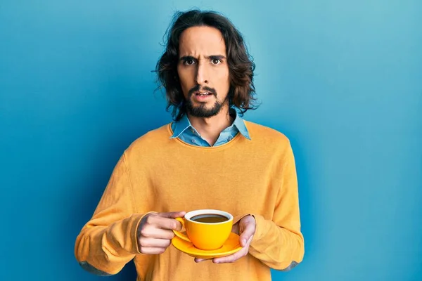 Joven Hispano Bebiendo Una Taza Café Sin Pistas Expresión Confusa —  Fotos de Stock