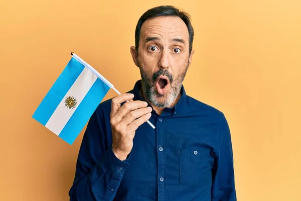 Středověký Hispánec Drží Argentinskou Vlajku Vyděšený Ohromený Otevřenými Ústy Pro — Stock fotografie