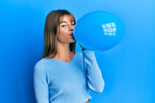 Beyaz Kadın Mavi Arka Planda Balon Şişiriyor — Stok fotoğraf
