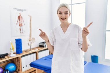 Ağrı kesici kliniğinde çalışan beyaz bir kadın farklı yönleri işaret ederek gülümsüyor. reklam için kopyalama alanı 