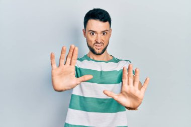 Latin asıllı genç bir adam, sıradan kıyafetler giyip avuçlarını hareket ettiriyor. Korkmuş ve iğrenç bir ifadeyle reddediyor. Dur ve yasakla. 