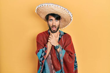 Meksikalı şapkalı İspanyol genç adam boğularak can çekiştiği için bağırıyor ve boğuluyor. Sağlık problemi. Boğulma ve intihar konsepti. 