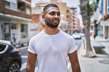 Orta Doğu 'lu genç adam gülümsüyor. Mutlu bir şekilde şehirde duruyor..