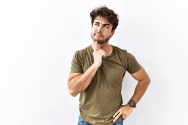 İzole edilmiş beyaz arka planda duran İspanyol bir adam parmak çenesinde şüpheye yoğunlaşmıştı ve merak ediyordu. 