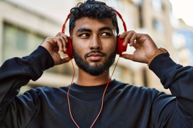 Genç Arap adam sokakta müzik dinleyerek rahatladı.