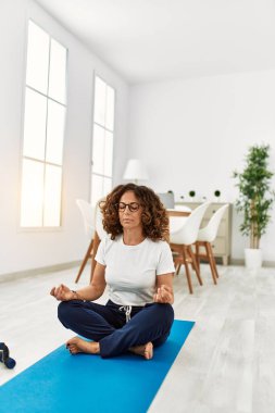 Evde yoga yapan genç bir kadın.