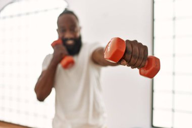 Spor merkezinde dambılı olan genç Afro-Amerikan boksör.