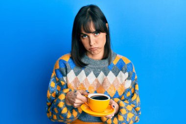 Genç İspanyol kadın bir fincan kahve içiyor. Depresyonda ve üzüntüden ağlıyor. Kızgın ve korkmuş. hüzünlü ifade. 