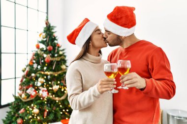 Genç İspanyol çift evde şampanyayla öpüşüyor ve kadeh kaldırıyor..