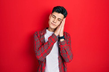 Gündelik kıyafetler giyen genç İspanyol adam uyur. Yorgun düşler kurar, ellerle poz verir, gözleri kapalı gülümserdi.. 