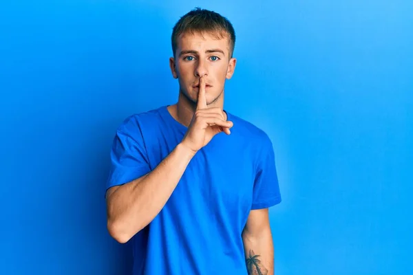 年轻的高加索男人穿着休闲的蓝色T恤 要求保持安静 手指放在嘴唇上 沉默和秘密概念 — 图库照片