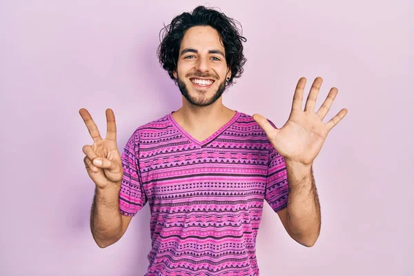 英俊的惊慌失措的男人穿着休闲的粉色T恤 用七号手指指尖 面带微笑 自信而快乐 — 图库照片