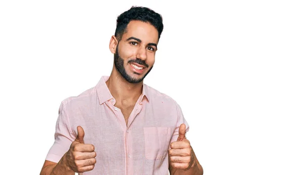 髭を生やしたヒスパニック系の男性は カジュアルなシャツの成功のサインを手で積極的なジェスチャーを行うと 親指を笑顔と幸せ 陽気な表情と勝者のジェスチャー — ストック写真