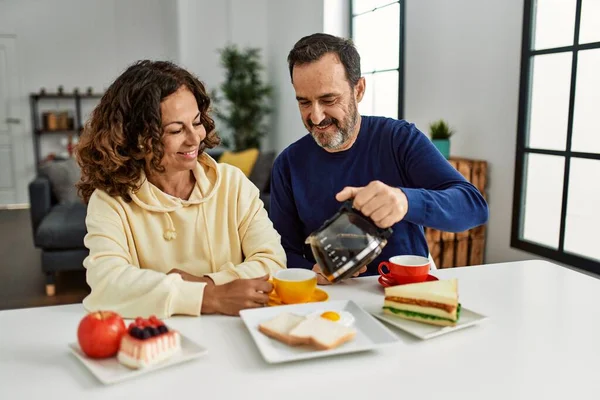 Pareja Hispana Mediana Edad Sonriendo Feliz Sentada Mesa Desayunando Casa —  Fotos de Stock
