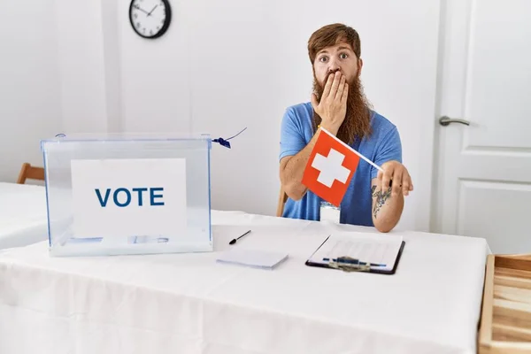 在政治竞选中蓄着长胡子的高加索人手拿着瑞士国旗捂着嘴 震惊而又害怕犯错 惊讶的表情 — 图库照片