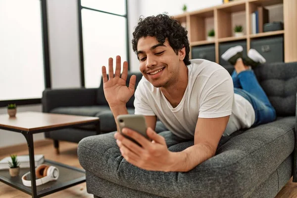 Young Hispanic Man Having Video Call Using Smartphone Lying Sofa — Stock Photo, Image