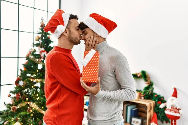 Two Hispanic Men Couple Kissing Surprise Gift Standing Christmas Tree — Stock Photo, Image