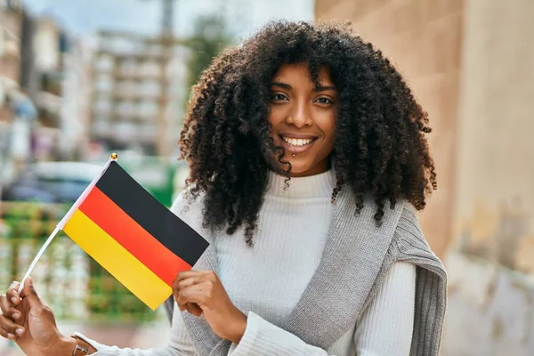 Joven Mujer Afroamericana Sonriendo Feliz Sosteniendo Bandera Alemania Ciudad —  Fotos de Stock