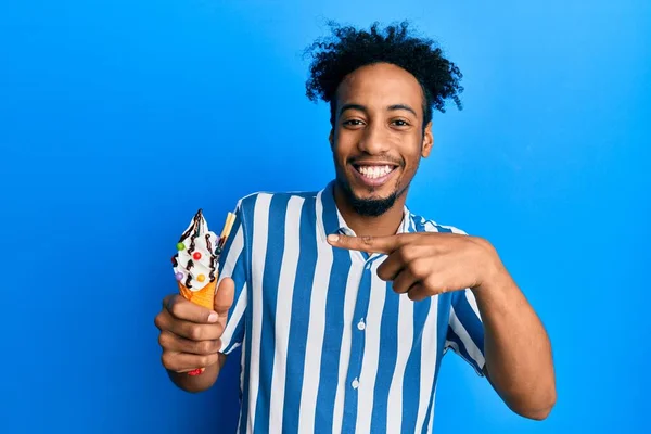 Νεαρός Αφροαμερικάνος Γενειάδα Τρώει Παγωτό Χαμογελώντας Χαρούμενος Δείχνοντας Χέρι Και — Φωτογραφία Αρχείου