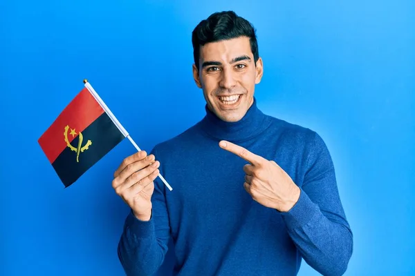 Hombre Hispano Guapo Sosteniendo Bandera Angola Sonriendo Feliz Señalando Con —  Fotos de Stock