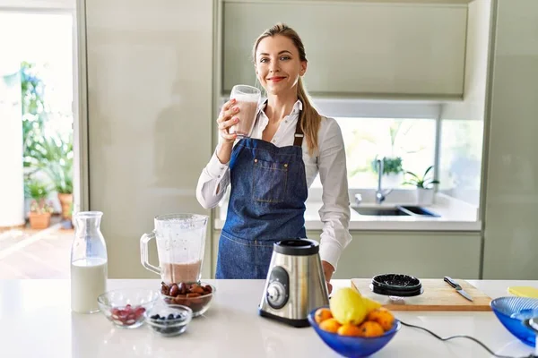 Genç Sarışın Kadın Gülümsüyor Mutfakta Buzlu Içecek Bardağı Tutuyor — Stok fotoğraf