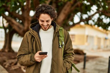 Şehirde akıllı telefon kullanan yakışıklı bir İspanyol.