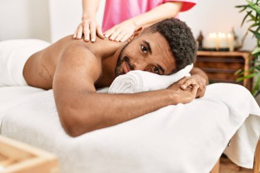 Genç Afro-Amerikan gülümsemesi Güzellik Merkezi 'nde sırt masajı alırken.