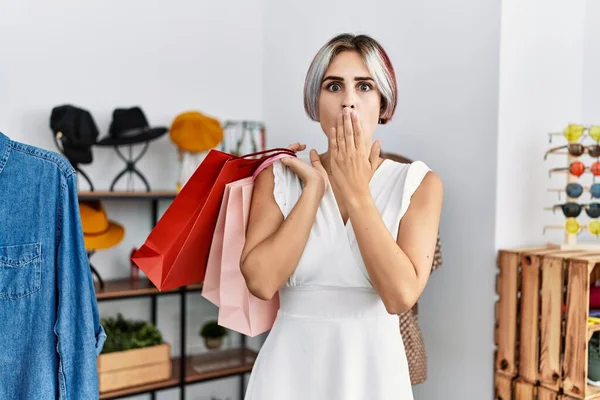 若い美しい女性は手で口をカバー小売店で買い物袋を保持し ショックを受け 間違いを恐れている 驚きの表情 — ストック写真