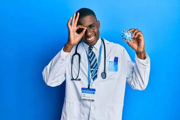 Jovem Afro Americano Vestindo Casaco Médico Segurando Vírus Brinquedo Sorrindo — Fotografia de Stock