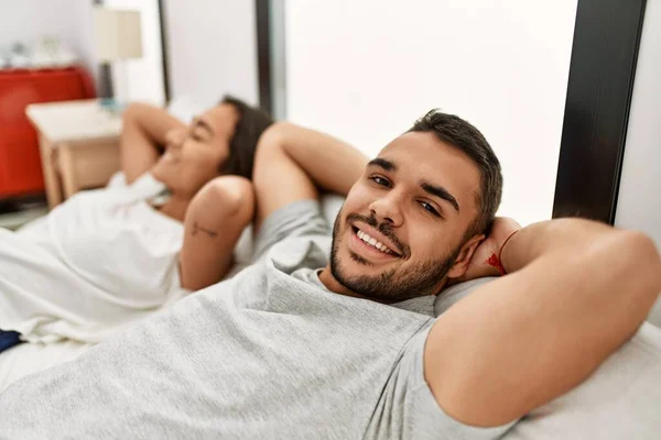 Unga Latinamerikanska Par Slappnar Med Händerna Huvudet Liggande Sängen Hemma — Stockfoto